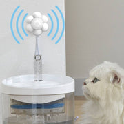 White infrared sensor pet water fountain with flowing water and a white cat looking at the dispenser
